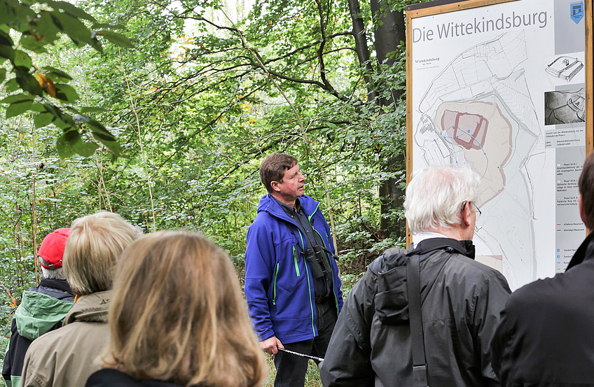 Auf dem Plan erläutert Udo Stangier die geschützte Lage und den Verlauf der Wälle auf der Wittekindsburg. Foto: Heinrich Vennemann