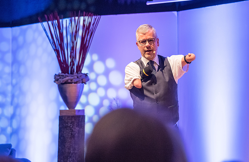 Pfarrer Rainer Schmidt „predigt“ humorvoll auf der Bühne.