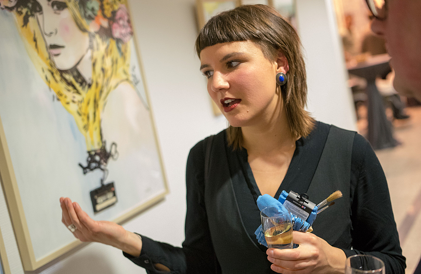 Katrin Lazaruk erklärt den Ausstellungsbesuchern, wie sie ihre Werke erstellt.