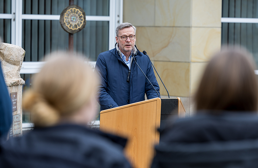 Bürgermeister Otto Steinkamp spricht vor Schülern der Alexanderschule und Ratsmitgliedern.