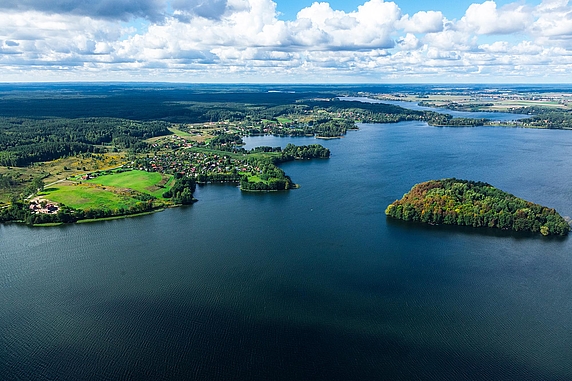 Luftbild von Stawiguda mit Blick auf einen See mit Siedlungen und Wäldern.