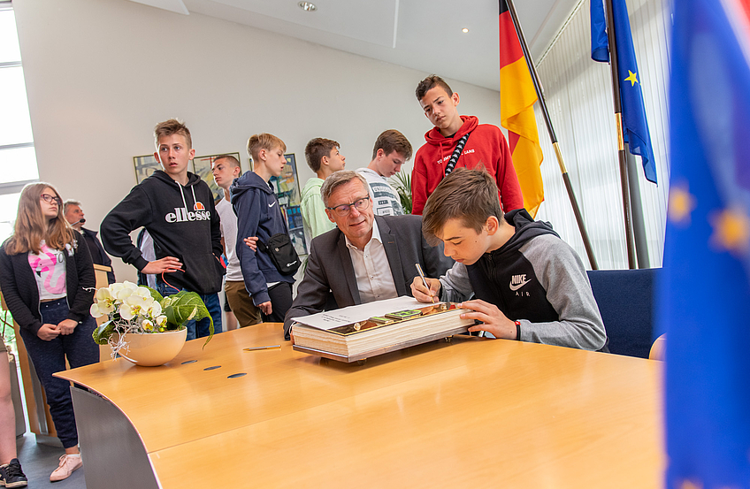 Die Jugendlichen aus Olsztyn tragen sich im Beisein von Bürgermeister Otto Steinkamp ins Goldene Buch der Gemeinde Wallenhorst ein.