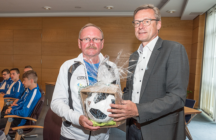 Mit Blick auf die kommende Fußballweltmeisterschaft überreicht Bürgermeister Otto Steinkamp (rechts) das passende Spielgerät als Gastgeschenk an Trainer Jerzy Budziłek.