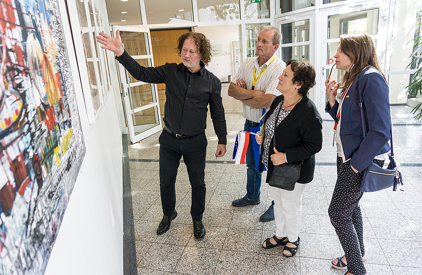 Witold Podgórski (links) erläutert seine Werke, die aktuell im Wallenhorster Rathausfoyer zu sehen sind.