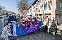 Gruppenfoto mit Fahne vor dem Rathaus