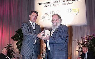 Bürgermeister Belde überreicht Eddy Stiene den Stein des Anstoßes 