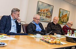 Bürgermeister Otto Steinkamp (links) hört interessiert zu, als Josef Torbecke (2. von links) auf die Anfänge der Archivgruppe zurückblickt.